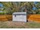 The backyard storage shed is framed by lush landscaping and a wooden fence at 1200 74Th N St, St Petersburg, FL 33710