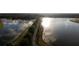 Picturesque aerial view of a walking path and lake at sunset with sun glistening off the water at 12307 Blue Hill Trl, Bradenton, FL 34211