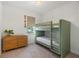 Bedroom with a green bunk bed, wood dresser, neutral paint, and natural light at 12307 Blue Hill Trl, Bradenton, FL 34211