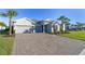 Charming single-story home with a three-car garage, beautiful landscaping, and a brick driveway at 12307 Blue Hill Trl, Bradenton, FL 34211