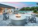 Cozy fire pit with comfortable seating and a pool in the background, perfect for outdoor gatherings at 12307 Blue Hill Trl, Bradenton, FL 34211