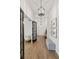 Hallway with wood look flooring, modern lighting fixture, bench, and decorative photographs at 12307 Blue Hill Trl, Bradenton, FL 34211