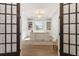 Bright office featuring built-in bookshelves and a large desk viewed through french doors at 12307 Blue Hill Trl, Bradenton, FL 34211