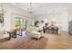 Open-concept living room with white sofa, large area rug, and kitchen view at 12307 Blue Hill Trl, Bradenton, FL 34211