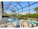 Gorgeous pool and spa with a screened enclosure, patio furniture, and lush landscaping at 12307 Blue Hill Trl, Bradenton, FL 34211