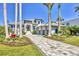 View of the home showcasing its exterior, manicured landscaping, three-car garage, and paver driveway at 1333 Vista Dr, Sarasota, FL 34239