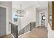 Elegant staircase with decorative railing, hardwood floors, and modern chandelier at 1333 Vista Dr, Sarasota, FL 34239
