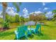 Inviting backyard with Adirondack chairs, a small table, and a serene pond view at 13708 Red Rock Pl, Lakewood Ranch, FL 34202