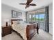 Cozy bedroom with a private balcony overlooking lush greenery and a ceiling fan at 13708 Red Rock Pl, Lakewood Ranch, FL 34202