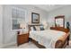 Comfortable bedroom featuring natural light, a decorative painting, and matching nightstand and dresser set at 13708 Red Rock Pl, Lakewood Ranch, FL 34202