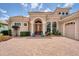 Mediterranean-style home featuring an arched entryway, paver driveway, and a three-car garage at 13708 Red Rock Pl, Lakewood Ranch, FL 34202