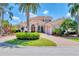 Elegant Mediterranean-style home featuring a tile roof, paver driveway, and lush tropical landscaping at 13708 Red Rock Pl, Lakewood Ranch, FL 34202