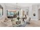 Elegant living room featuring a chandelier, neutral furniture, and an opening to an outdoor patio at 13708 Red Rock Pl, Lakewood Ranch, FL 34202