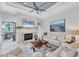 Bright living room with stone fireplace, modern ceiling fan, and comfortable seating arrangement at 13708 Red Rock Pl, Lakewood Ranch, FL 34202