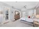Bright main bedroom with neutral tones, light carpet, a ceiling fan, and wooden dresser at 13708 Red Rock Pl, Lakewood Ranch, FL 34202