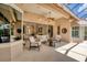 Covered patio with comfortable seating, ceiling fan, and sliding glass doors leading to the home's interior at 13708 Red Rock Pl, Lakewood Ranch, FL 34202