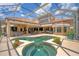 A luxurious screened-in pool and spa area with an outdoor kitchen and covered lanai for entertaining at 13708 Red Rock Pl, Lakewood Ranch, FL 34202
