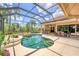 Outdoor living with a beautiful pool, bar seating, outdoor kitchen, and dining area under a screened lanai at 13708 Red Rock Pl, Lakewood Ranch, FL 34202