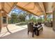 Enclosed pool area with dining, outdoor kitchen, seating, and sunshades, with beautiful views of the landscaped yard at 13708 Red Rock Pl, Lakewood Ranch, FL 34202