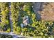 Aerial view of house with screened pool, nestled among mature trees at 13955 Pine Woods E Ln, Sarasota, FL 34240
