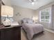 Bright bedroom featuring neutral walls, light purple bedding, and a ceiling fan at 13955 Pine Woods E Ln, Sarasota, FL 34240
