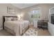 Cozy bedroom with a neutral color palette, plantation shutters, and a dedicated work area at 13955 Pine Woods E Ln, Sarasota, FL 34240