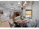 Dining area with pool view, elegant chandelier, seating for six, and natural light, creating a cozy atmosphere at 13955 Pine Woods E Ln, Sarasota, FL 34240