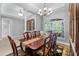 Formal dining room with wooden table, seating for eight, elegant chandelier, and natural light at 13955 Pine Woods E Ln, Sarasota, FL 34240