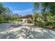 Charming home features a large driveway, 2-car garage, and lush tropical landscaping at 13955 Pine Woods E Ln, Sarasota, FL 34240