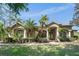 Beautiful single-story home featuring lush landscaping, a well-manicured lawn, and an inviting entryway at 13955 Pine Woods E Ln, Sarasota, FL 34240