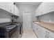 Functional laundry room with modern appliances, ample storage, and a convenient sink at 13955 Pine Woods E Ln, Sarasota, FL 34240