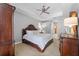 Spacious main bedroom with tray ceiling, ceiling fan, carpet flooring, and elegant wood furniture at 13955 Pine Woods E Ln, Sarasota, FL 34240