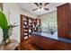 Wood-paneled home office featuring built-in bookshelves and a large window overlooking the backyard at 13955 Pine Woods E Ln, Sarasota, FL 34240