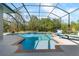 Sparkling pool in screened lanai with lounge seating and lush natural surroundings at 13955 Pine Woods E Ln, Sarasota, FL 34240