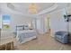 Bright main bedroom featuring a tray ceiling, a charming chandelier, and an ensuite bathroom at 15039 Black Cherry Way, Punta Gorda, FL 33955