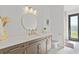 Modern bathroom with sleek vanity, gold fixtures, and a glass door to outside at 16768 San Edmundo Rd, Punta Gorda, FL 33955
