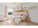 Charming bedroom with a unique wooden bunk bed, pink accents, and plenty of natural light from a large window at 16768 San Edmundo Rd, Punta Gorda, FL 33955