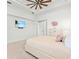 Bright bedroom with ceiling fan, white walls and carpet, complemented by stylish decor and a mounted television at 16768 San Edmundo Rd, Punta Gorda, FL 33955