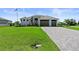 Beautiful single-story home with three-car garage, manicured lawn, and brick paved driveway at 16768 San Edmundo Rd, Punta Gorda, FL 33955