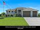 Beautifully landscaped single-Gathering home with a three-car garage and a well manicured lawn at 16768 San Edmundo Rd, Punta Gorda, FL 33955