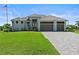 Beautiful single-story home with three-car garage, manicured lawn, and brick paved driveway at 16768 San Edmundo Rd, Punta Gorda, FL 33955