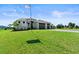 Beautifully landscaped front yard with lush green lawn, palm trees, and a circular driveway leading to a modern home at 16768 San Edmundo Rd, Punta Gorda, FL 33955