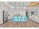 Modern kitchen with white cabinets, granite countertops, stainless steel appliances, and bright blue bar stools at 16768 San Edmundo Rd, Punta Gorda, FL 33955