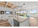 Modern kitchen features an island with granite countertop overlooking the bright living room with outdoor views at 16768 San Edmundo Rd, Punta Gorda, FL 33955