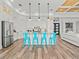 Modern kitchen with white cabinets, stainless steel appliances, large island with blue bar stools, and hardwood floors at 16768 San Edmundo Rd, Punta Gorda, FL 33955