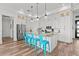 Modern kitchen with white cabinets, granite countertops, stainless steel appliances, and bright blue bar stools at 16768 San Edmundo Rd, Punta Gorda, FL 33955