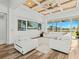 Spacious living room and kitchen layout with hardwood floors, coffered ceilings, and white furniture at 16768 San Edmundo Rd, Punta Gorda, FL 33955