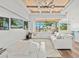 Bright living room featuring wood floors, coffered ceilings, and large sliding doors opening to the outdoors at 16768 San Edmundo Rd, Punta Gorda, FL 33955