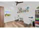 Bright office space with modern desk, floating shelves, and wood-look flooring for a comfortable workspace at 16768 San Edmundo Rd, Punta Gorda, FL 33955