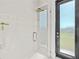 Contemporary shower with glass door, sleek fixtures, and white tile with decorative accent at 16768 San Edmundo Rd, Punta Gorda, FL 33955